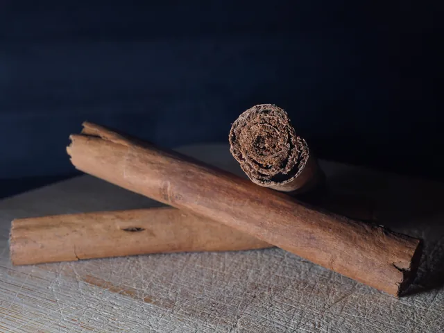 Two whole cinnamon sticks on a wooden surface